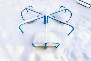 Schneebedecktes Kinderkarussell am Wintermorgen foto