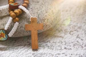 heiliger rosenkranz auf stein mit hellem lichtschein. spirituelles und christliches Konzept foto