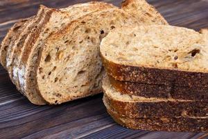 frische Brotscheiben auf Schneidebrett vor weißem Hintergrund aus Holz foto