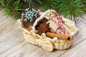 festliche geschenke mit boxen, sternanis, korb, zimt und schneeflocke auf holzhintergrund. weihnachtsgeschenke mit kopierraum foto