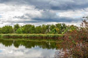 ein Fluss und die dramatische Wolkenlandschaft nach dem Regen. Wetterwechsel foto