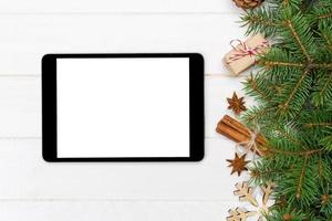 digitales tablet-modell mit rustikalen weihnachtlichen hölzernen hintergrunddekorationen für app-präsentation. draufsicht mit kopierraum foto