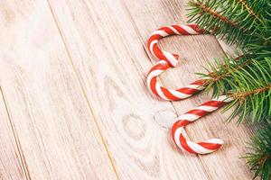 Weihnachtsbaumzweig und Zuckerstange auf einem Holztisch oder Brett für den Hintergrund. Thema des neuen Jahres. Platz für Text. getönt foto