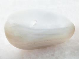 Polierter weißer Achat-Edelstein auf Weiß foto
