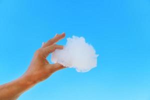 weiße Wolke in der Hand gegen den blauen Himmel. foto