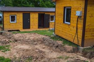 bau von kleinen gelben holzrahmen vorgefertigten vorgefertigten öko-häusern aus vorstädtischen modularen schnell wachsenden häusern, gebäuden, hütten. Industriebau foto