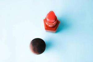 schönheitsbox, satz weiblicher kosmetik aus dem roten lippenstift und textmarker auf blauem hintergrund. flach liegen. Ansicht von oben foto