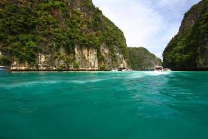 landschaft der andamanensee mit felsberg oder insel und schnellboote bringen touristen, reisende oder menschen zum besuchen des strandes, des schönen ozeans in krabi, thailand. Wahrzeichen für Reisen und Schönheit der Natur. foto