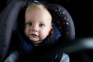 Porträt eines süßen Babys in einem Autositz in einem Auto foto