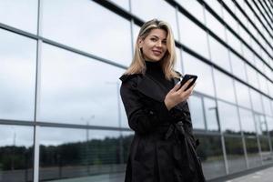 Geschäftskorrespondenz Geschäftsfrau mittleren Alters auf dem Hintergrund eines gläsernen Bürogebäudes foto