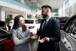 eine junge frau verhandelt eine langfristige automiete bei einem autohaus, konzept nach dem autogarantieservice foto