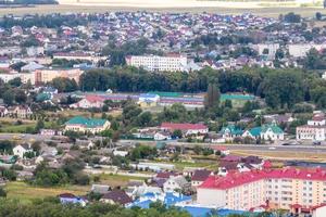 Luftpanorama aus großer Höhe einer kleinen Provinzstadt mit privatem Sektor und Wohnhochhäusern foto