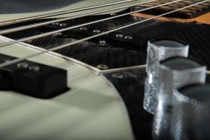 nahaufnahme der gitarrenbasssaitendetails, vier eisensaiten, weiße und schwarze farbe foto