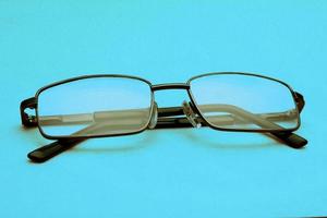 Brille in einem schwarzen Rahmen auf blauem Hintergrund mit Kopierraum. Welttag des Sehens. foto