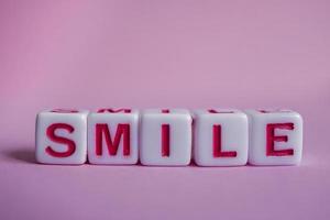 Lächelnwort mit roten Würfelbuchstaben, Gefühlen und Emotionen foto