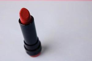 rotes modisches Lipour-Lipad und Textmarker auf blauem Hintergrund eines Schönheits-Make-up-Tisches. flach liegen. Ansicht von oben foto