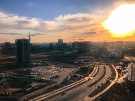 neue Gebäude unter der hellen, sengenden Sonne. neuer Ballungsraum, Hochhaus, stilvolle und schöne Blockhäuser auf vielen Etagen. Ausgrabungen zur Schaffung einer U-Bahn-Linie. Baustelle in der Stadt foto