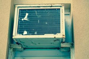 alte schlecht kaputte rechteckige minderwertige rostige klimaanlage zur kühlung der luft im sommer foto