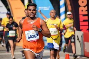 neu delhi, indien - 16. oktober 2022 - vedanta delhi halbmarathonrennen nach covid, bei dem die marathonteilnehmer kurz vor dem überqueren der ziellinie stehen, delhi halbmarathon 2022 foto