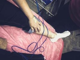 Eine Person erhält eine medizinische Bioimpedanzanalyse, um die Körperzusammensetzung zu diagnostizieren. Sensoren werden zur medizinischen Analyse und Patientenversorgung mit dem Bein verbunden foto