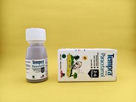 malang, indonesien - 22. oktober 2022 - paracetamolsirup mit marke tempra. Sirupflaschen und Kartonverpackungen mit isoliertem gelbem Hintergrund foto