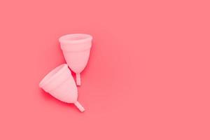 rosa menstruationstasse auf farbigem hintergrund, weibliche intimhygieneperiodenprodukte, draufsicht foto