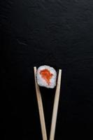 Sushi mit Thunfisch-Lachs-Reis und Essstäbchen auf einem isolierten Hintergrund