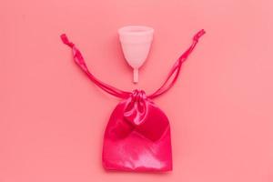 rosa menstruationstasse auf farbigem hintergrund, weibliche intimhygieneperiodenprodukte, draufsicht foto