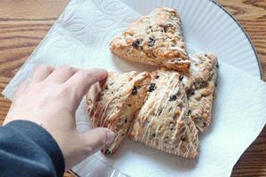 Scones mit blauen Beeren, serviert auf weißen Tellern foto