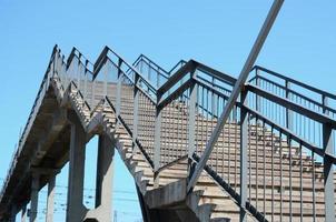 ein Fragment eines Stufenaufstiegs zur Fußgängerbrücke zwischen den Bahnsteigen foto