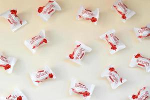 charkiw, ukraine - 02. mai 2021 raffaello-bonbons auf beigem hintergrund. Raffaello ist ein kugelförmiges Kokos-Mandel-Konfekt, das der italienische Hersteller Ferrero 1990 auf den Markt brachte foto