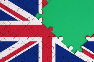 Die britische Flagge ist auf einem fertigen Puzzle mit freiem Platz für grüne Kopien auf der rechten Seite abgebildet foto