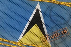 st. lucia-flagge und covid-19-biohazard-symbol mit orangefarbenem quarantäneband und stempel. Coronavirus- oder 2019-ncov-Viruskonzept foto