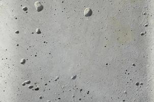 dunkelgraue betonstruktur, raue zementsteinwand, oberflächenkies der alten und schmutzigen außengebäudewand. abstrakter Hintergrund foto