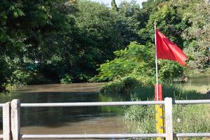 rote Flagge und gelbe Wasserstandsanzeige im Fluss foto