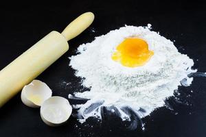 Mehl und Ei auf schwarzem Hintergrund foto