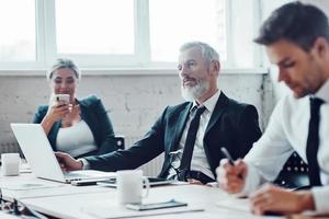 konzentrierte kollegen, die mitarbeiter treffen, während sie im modernen büro zusammenarbeiten foto