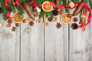 Weihnachtsdekoration mit Tannenbaum, Orangen, Zapfen, Gewürzen foto