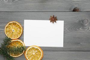Fichtenzweig mit getrockneten Orangenscheiben und Grußkarte foto
