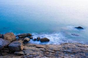 Naturansicht für sanfte Wellen und Stein im Meer am Morgen für Hintergrund und Textur foto