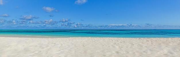 Nahaufnahme Sandstrand Meereswellen und blauer Sommerhimmel. Panorama-Strandlandschaft. leerer tropischer strand und seelandschaft, horizont. helle exotische küstenruhe, ruhige meeresnaturansicht entspannendes sonnenlicht foto