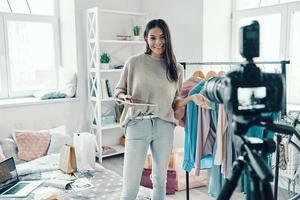 Schöne junge Frau in Freizeitkleidung, die Social-Media-Videos macht, während sie Zeit zu Hause verbringt foto