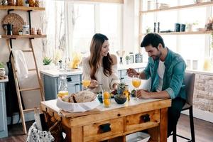 perfektes Frühstück. schönes junges Paar, das ein gesundes Frühstück genießt, während es zu Hause in der Küche sitzt foto