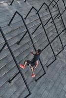 gibt sein Bestes. Draufsicht eines jungen Mannes in Sportkleidung, der die Treppe hinaufläuft, während er draußen trainiert foto