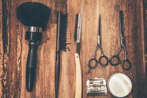 Friseurwerkzeuge. Draufsicht auf Barbershop-Werkzeuge, die auf der Holzmaserung liegen foto