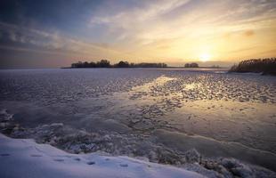 Winterlandschaft mit See und Sonnenuntergang feurigen Himmel. foto