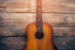 akustische Gitarre. Nahaufnahme der Gitarre, die auf Vintage-Holz-Hintergrund liegt foto