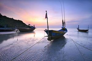 Boote am Strand während des Sonnenuntergangs leichte Seelandschaft in Thailand. foto