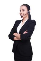 Kundendienstvertretung. Selbstbewusste junge Frau mit Headset, die lächelt und ihre Arme verschränkt hält, während sie isoliert auf Weiß steht foto