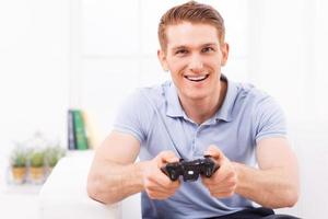 Mann spielt Videospiel. glücklicher junger mann, der joystick benutzt, während er zu hause videospiel spielt foto